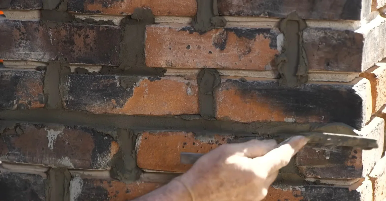 Tuckpointing fresh mortar into brick joints