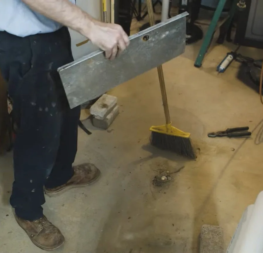 Removing a duct access panel beside swept debris